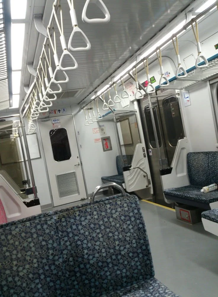 夜裡明亮而空蕩的列車車廂與握環