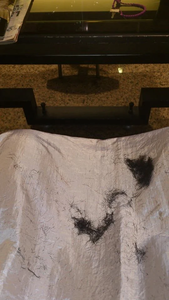 理髮後落在圍布上的髮絲